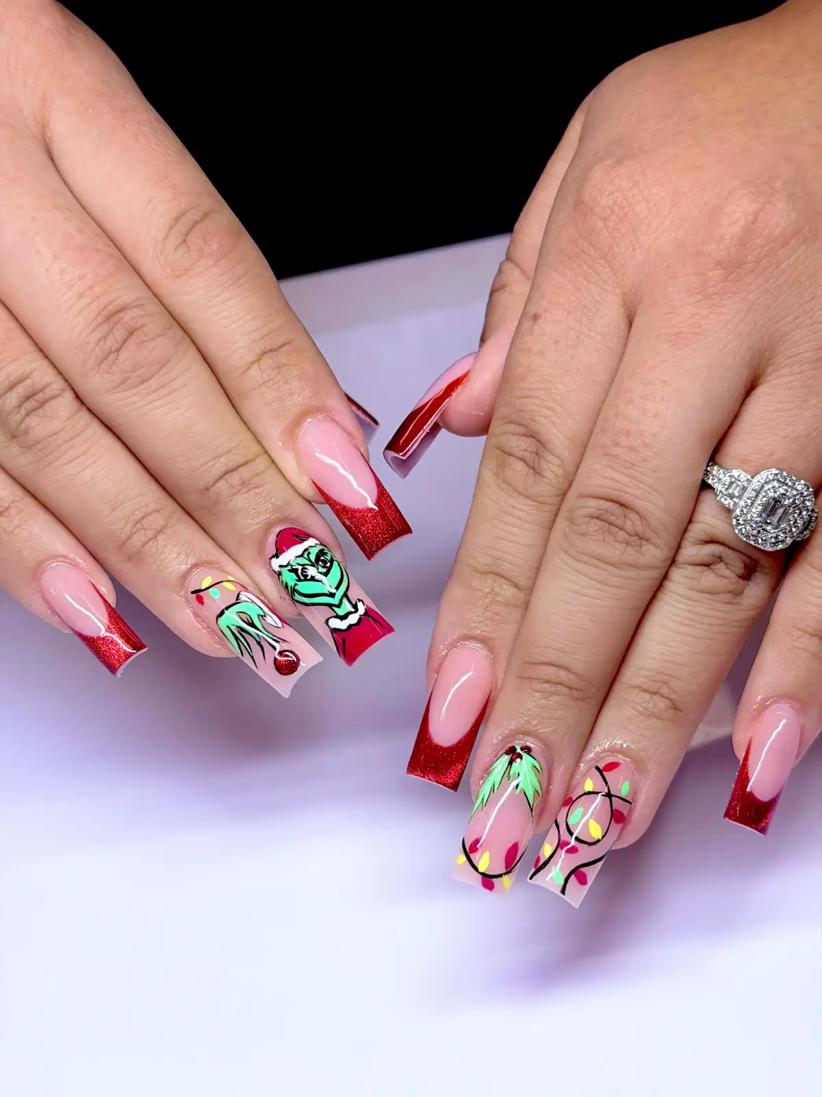 Red glitter French square nails with Grinch and Christmas light nail art
